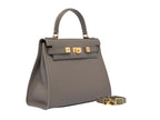 A large taupe coloured, natural grainy print Italian calf leather handbag with top handle, detachable strap and gold plated hardware.