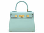 A medium-sized luxury Italian leather handbag in a soft aqua pale turquoise color with a grainy texture, featuring a top handle, a detachable shoulder strap and gold-plated hardware