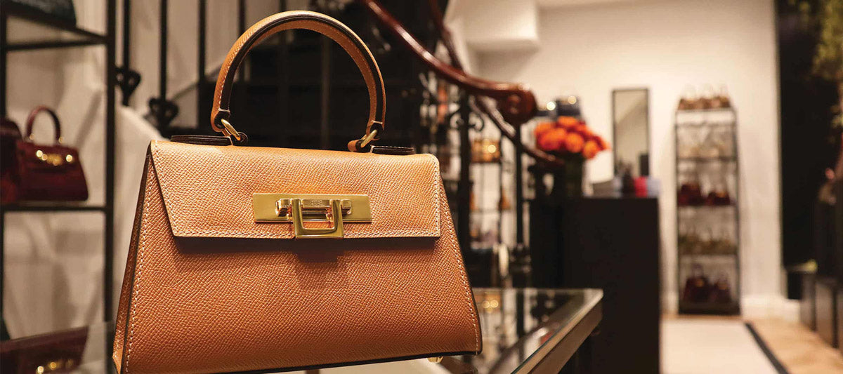 Brown Lalage Beaumont handbag with gold handle and clasp in Burlington Arcade store.