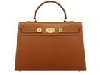 A large tan colored Italian calf leather handbag with pebble print texture, gold plated hardware, and a top handle with a detachable strap.