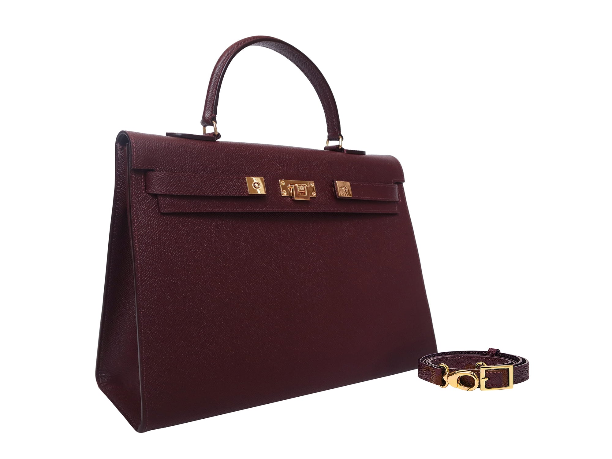 A large taupe colored Italian calf leather handbag with pebble print texture, gold plated hardware, and a top handle with a detachable strap.