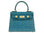 Blue textured ‘lizard’ print Italian leather handbag with gold hardware on a white background